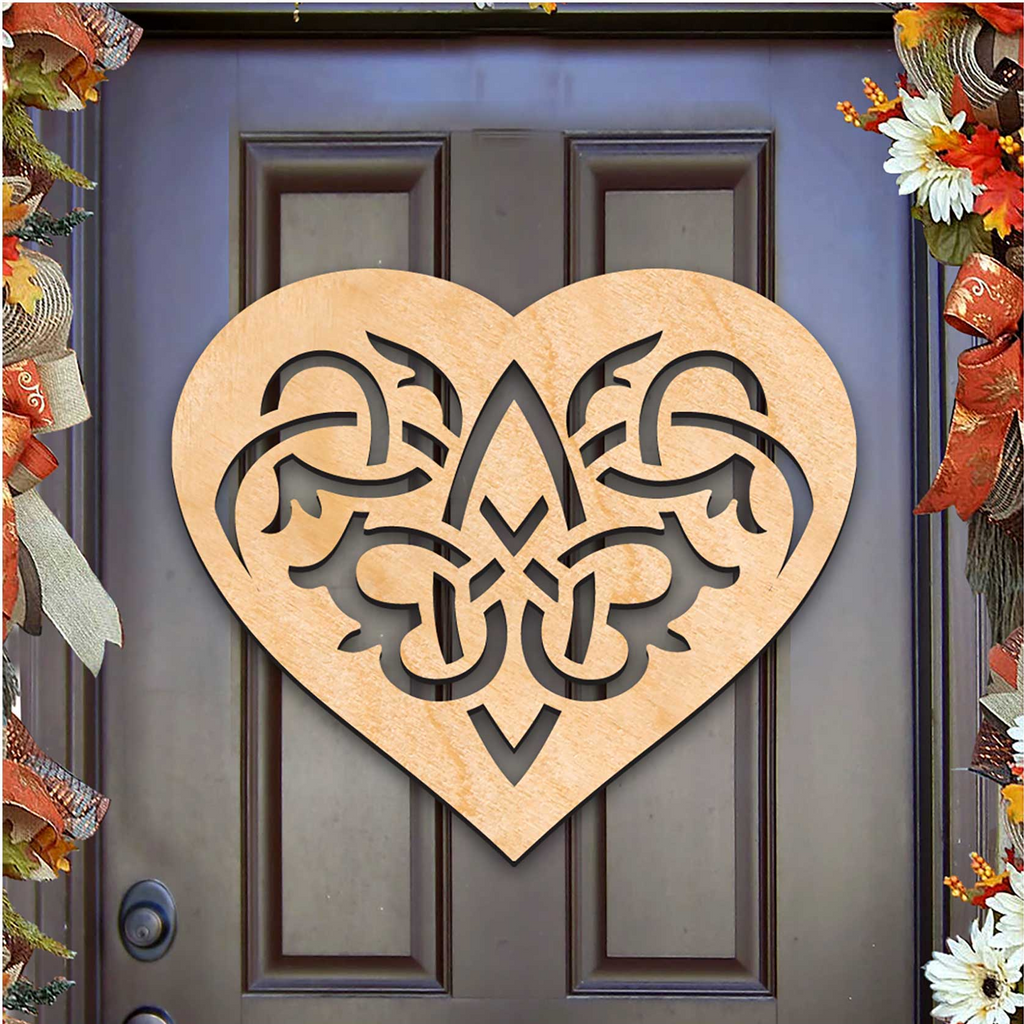 A heart-shaped wooden sign with intricate designs is displayed on a dark wooden door, surrounded by colorful fall decorations.