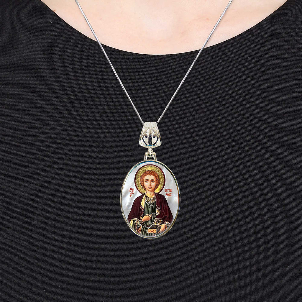 A silver necklace with a pendant featuring a religious icon of a person.