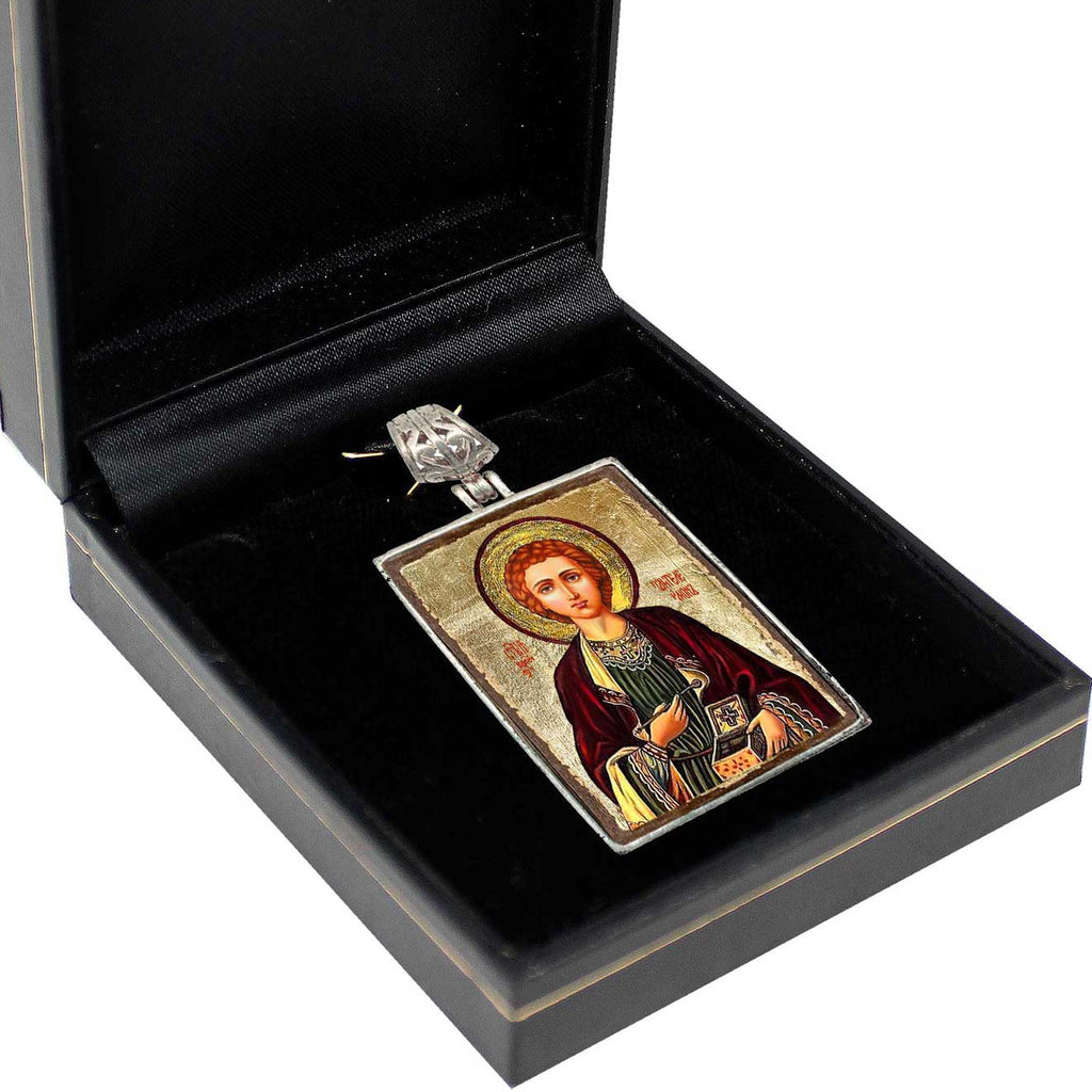 a pendant or religious icon displayed in a black box, which is placed on a white surface.
