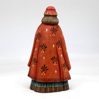 a ceramic figurine of a woman in a red dress