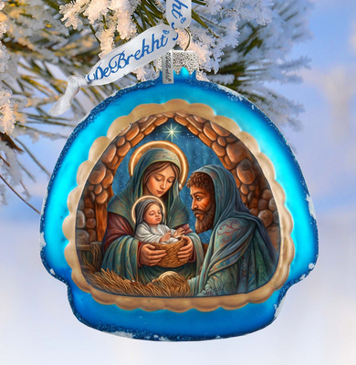 A blue ornament with a nativity scene depicting the Virgin Mary, baby Jesus, and the Holy Family in a snowy landscape.