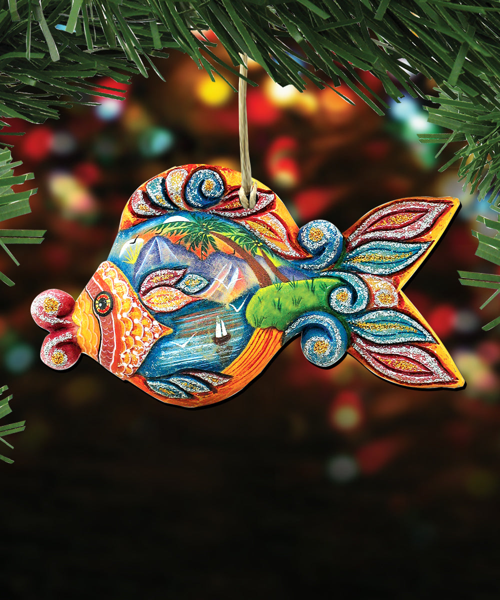 A colorful, handcrafted ornament in the shape of a fish, hanging from a string and surrounded by greenery.