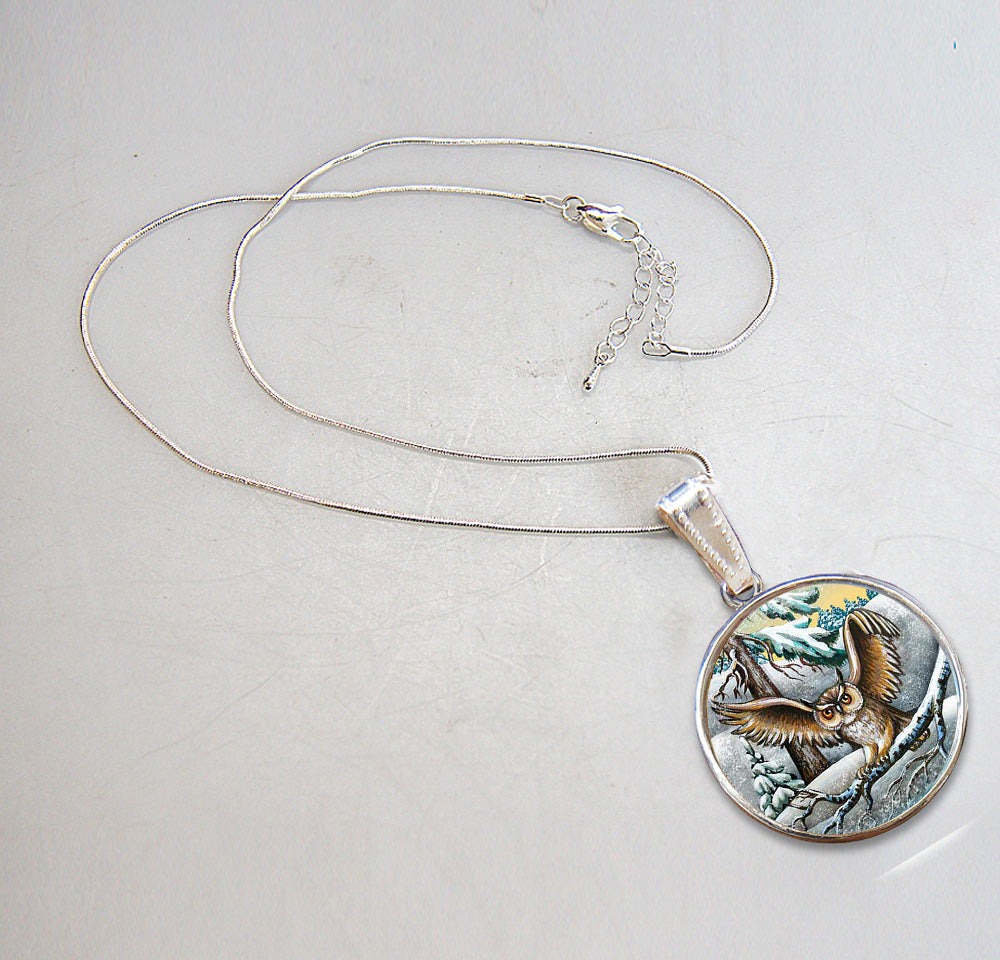 A silver necklace with a round pendant featuring an owl design.