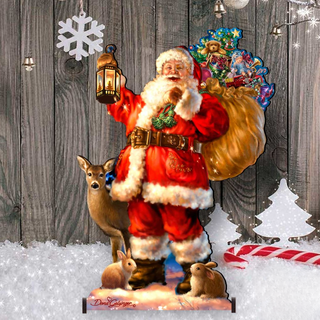 A cardboard cutout of Santa Claus holding a lantern and a sack of presents, with a deer and a rabbit in the background, set against a snowy landscape with Christmas decorations.