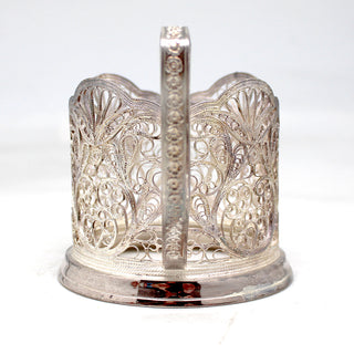 a silver candle holder with a candle inside of it