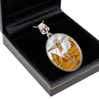 a pendant with a religious scene, depicting a figure on a cross, placed inside a black box.