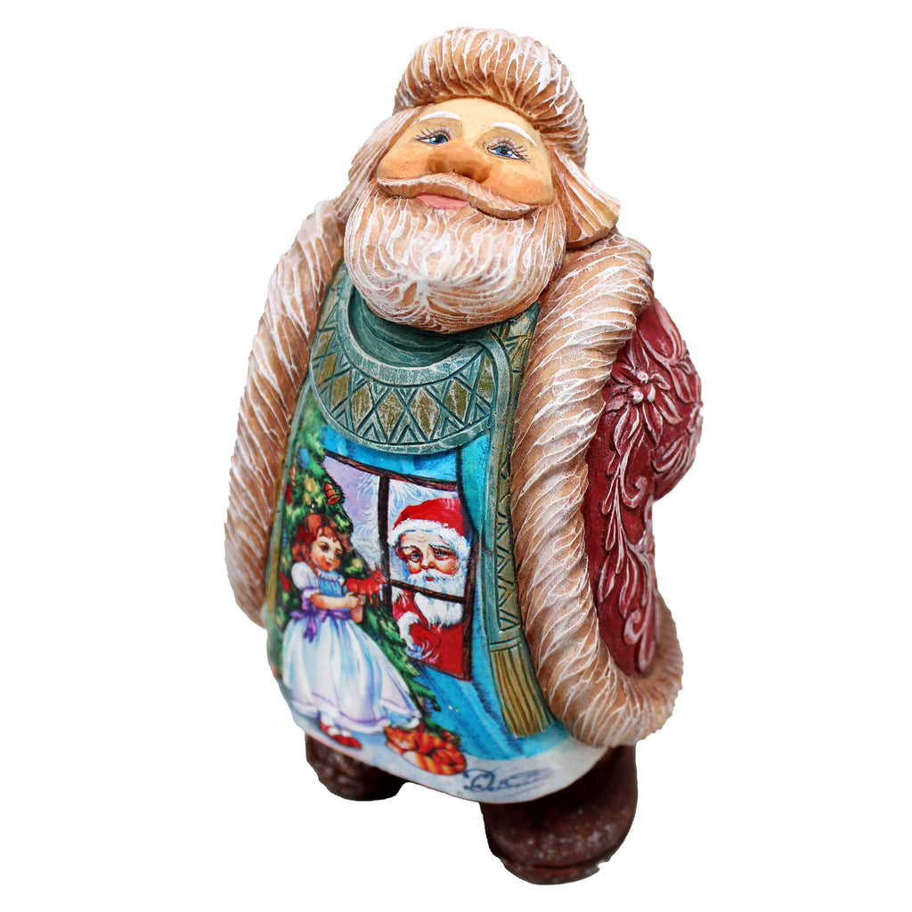 a ceramic figurine of a santa clause holding a christmas tree