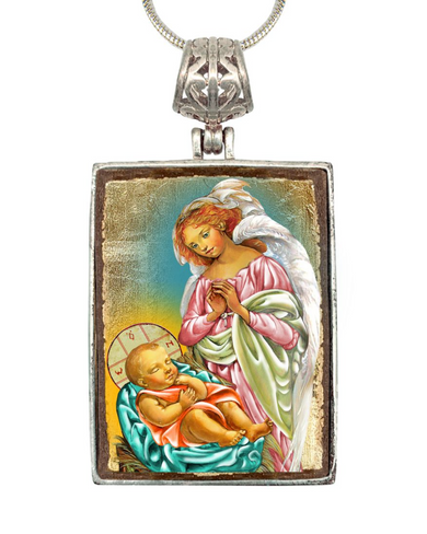 a pendant with a religious scene depicting a baby in a manger, accompanied by an angel.