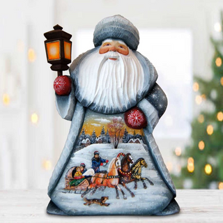 A figurine of Santa Claus holding a lantern and riding a sleigh pulled by reindeer, with a snowy winter landscape in the background.