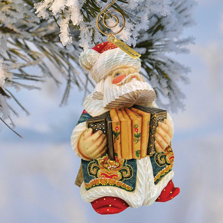 A decorative ornament of Santa Claus holding an accordion is hanging on a tree branch.