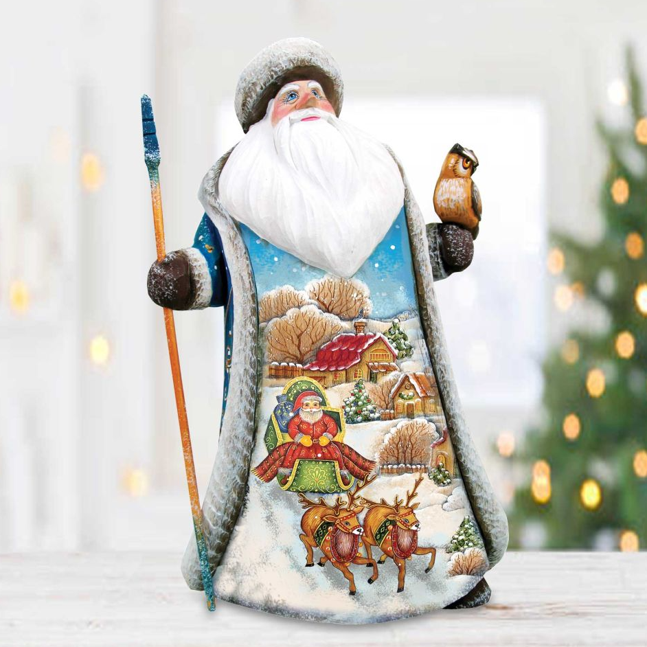 A figurine of Santa Claus holding a reindeer and a bird, with a snowy village scene depicted on his robe.