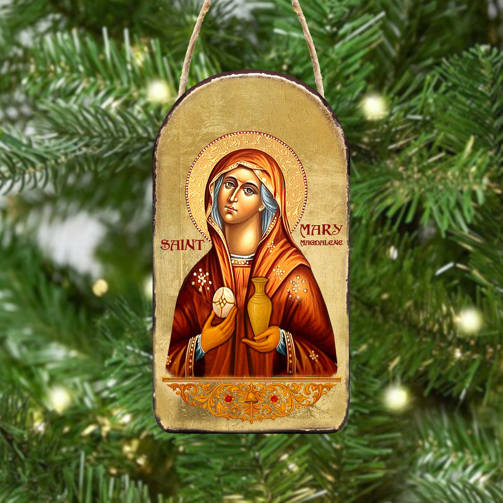 a Christmas ornament with a depiction of a religious figure, likely a saint or religious icon, hanging on a Christmas tree.