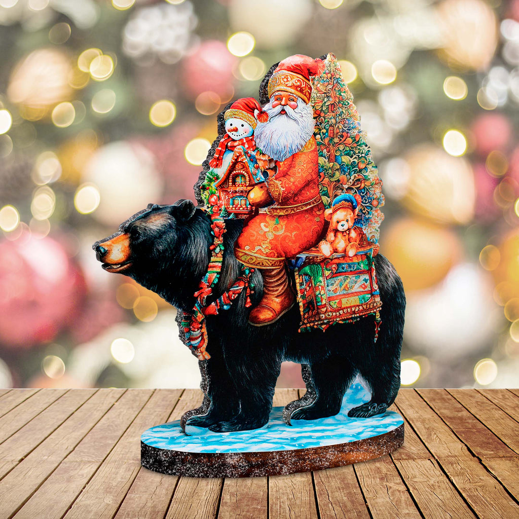 a statue of santa riding a bear on a wooden table