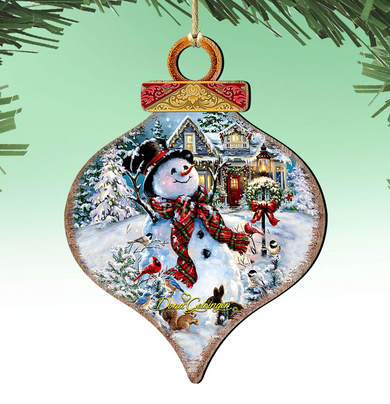 A snowman ornament with a wreath and a bird perched on its arm, set against a snowy winter landscape with a house and trees.