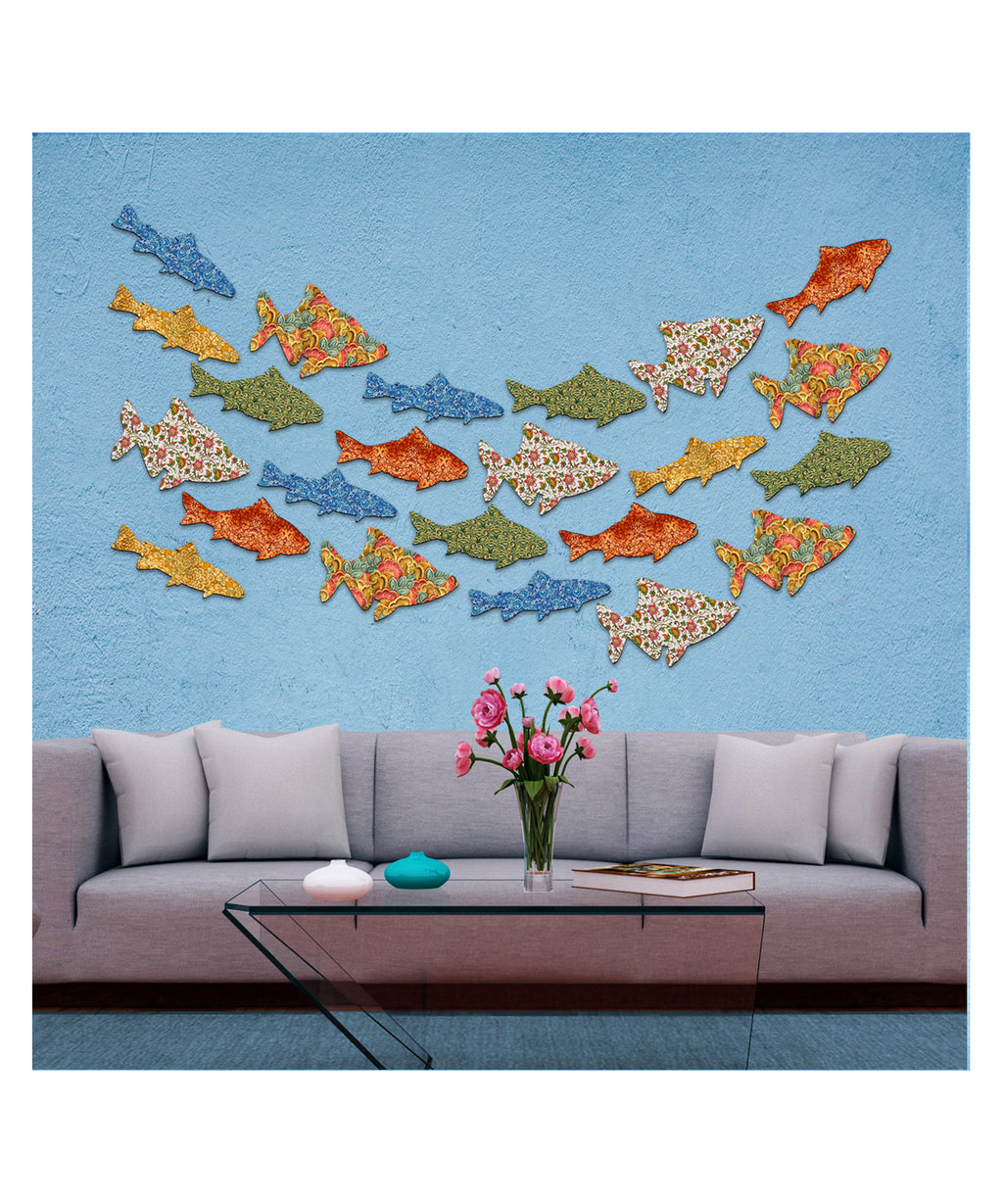 a modern living room with a gray sofa, a glass coffee table, and a wall adorned with colorful fish-shaped wall art. The fish are arranged in a visually appealing pattern, creating a lively and vibrant atmosphere in the room.