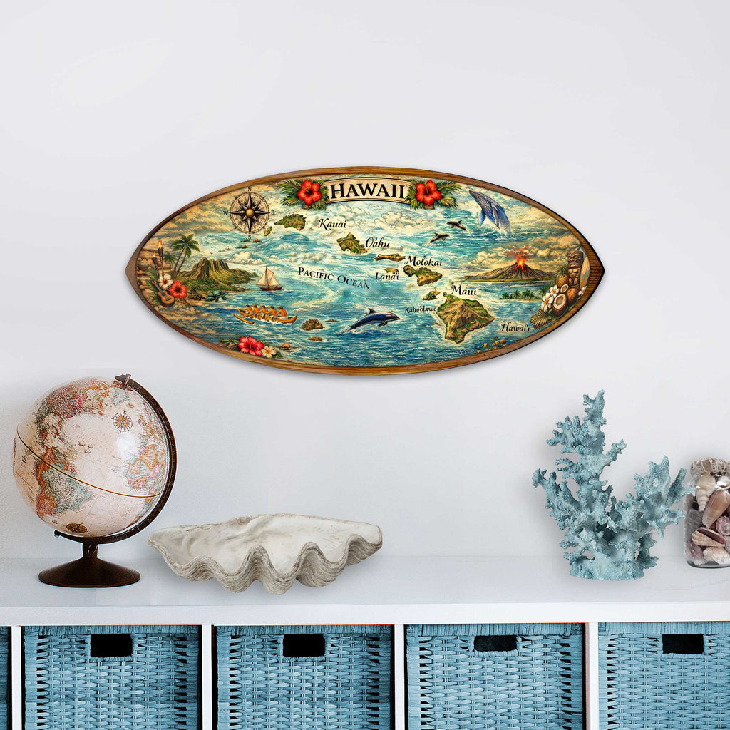 a decorative surfboard with a map of Hawaii, a globe, a shell, and some blue coral on a white shelf.