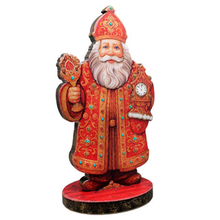 A wooden cutout of Santa Claus holding a cup and a clock.