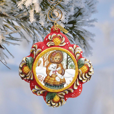 A decorative Christmas ornament featuring a woman holding a small dog, with a snowy background and a wreath-like design.