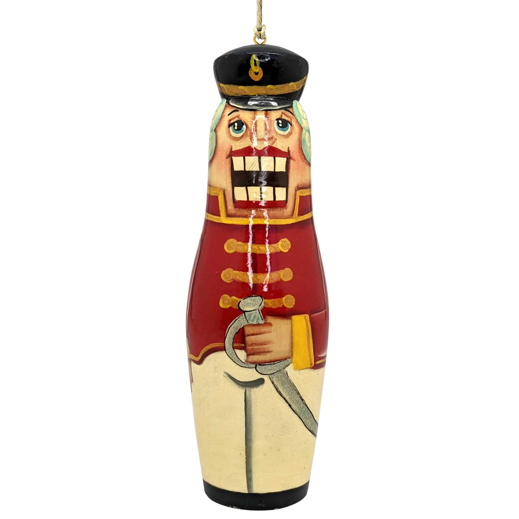 A nutcracker ornament with a red and gold color scheme, featuring a soldier-like figure holding a sword.