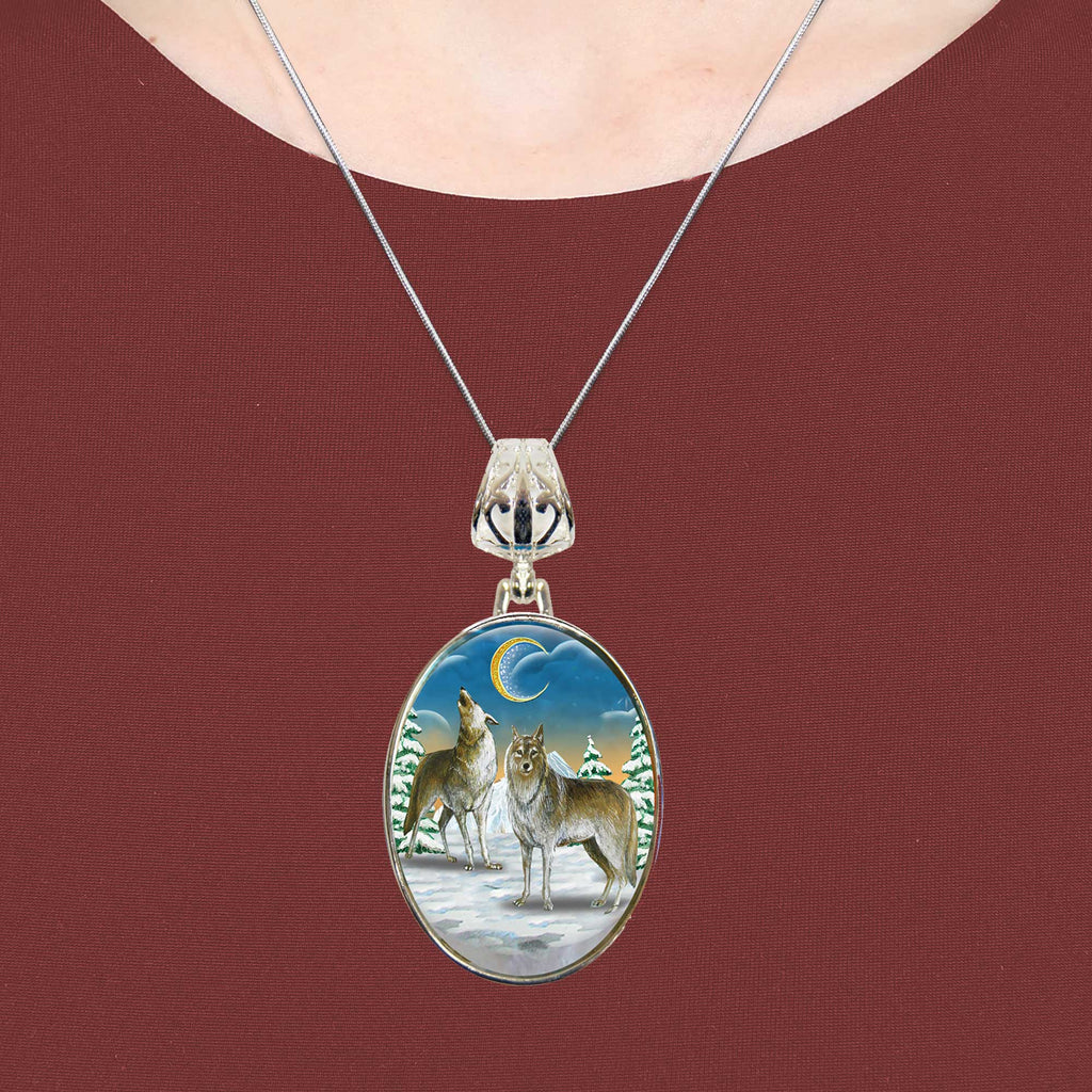 A necklace with a circular pendant featuring a painting of two wolves in a snowy landscape.