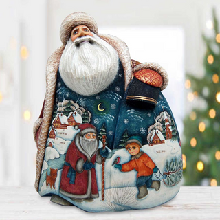 A figurine of Santa Claus holding a sack of presents, with a snowy landscape and a child in the background.