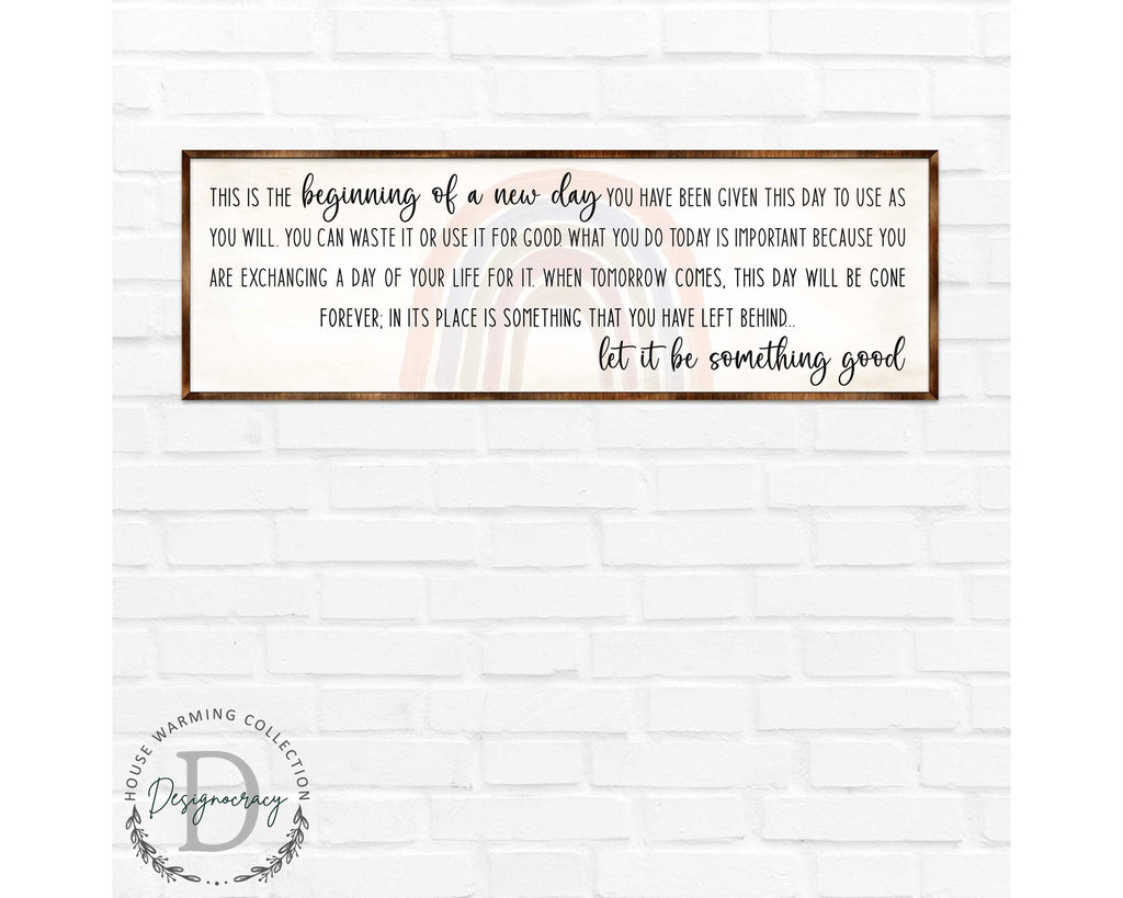 a framed inspirational quote on a white brick wall.