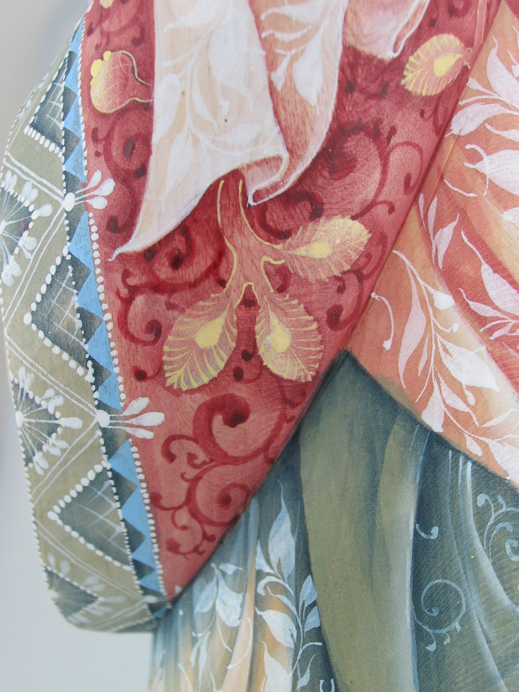 The image is a close-up of a colorful fabric with intricate floral patterns and designs.