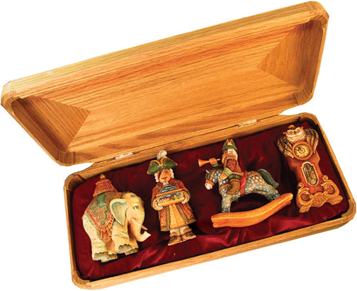 A wooden box containing four figurines, including an elephant, a man on a rocking horse, and a clock.