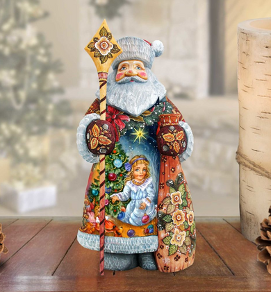 A colorful and intricately painted figurine of Santa Claus holding a star-shaped staff and a Christmas tree, set against a blurred background.