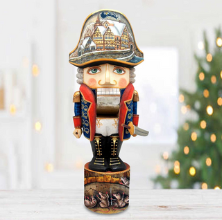 A wooden nutcracker figure with a detailed design, including a hat with a castle or palace scene, stands on a wooden base.
