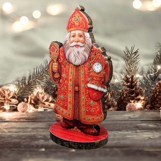 A wooden Santa Claus figurine holding a clock and a rooster stands on a wooden surface, surrounded by pine cones and Christmas lights.