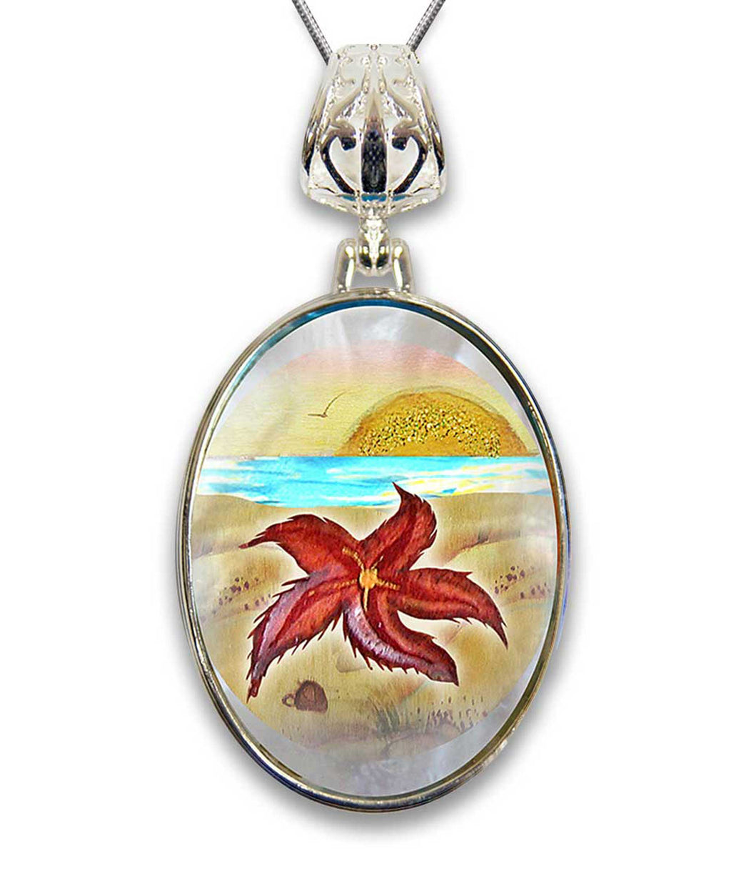 A pendant necklace with a circular design featuring a red starfish against a beach scene with a sunset in the background.