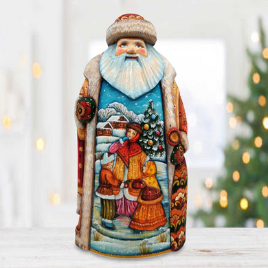 A colorful, hand-painted figurine of Santa Claus, featuring a winter scene with people, a Christmas tree, and other festive elements.