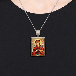 A silver necklace with a rectangular pendant featuring an image of a religious figure.