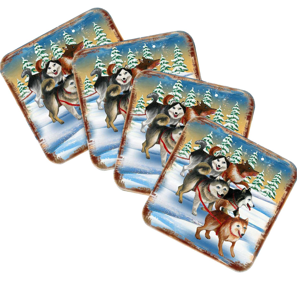 A set of four square coasters featuring illustrations of sled dogs in a snowy winter landscape.