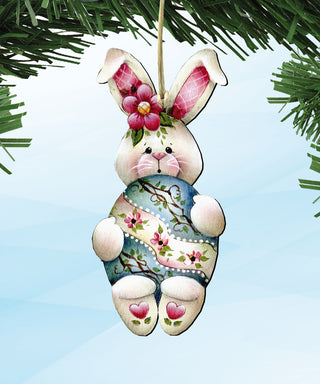 A decorative Easter bunny ornament with a floral pattern and a pink flower on its head, hanging from a string.