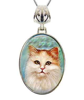 A silver pendant necklace with a round oval-shaped frame that contains a close-up portrait of a fluffy white cat with yellow eyes.