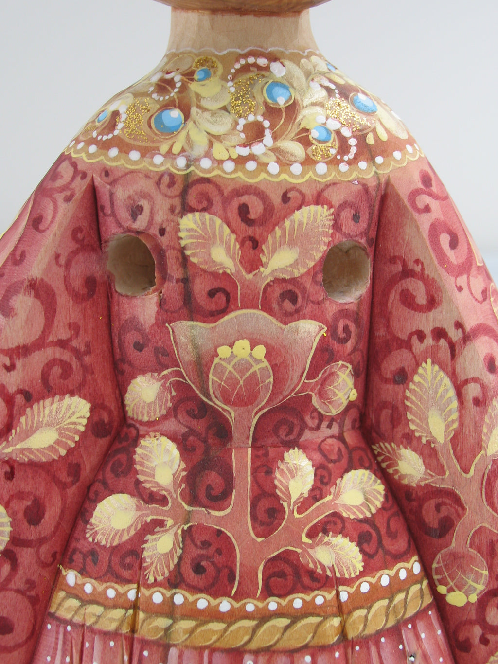 a close-up view of a beautifully decorated vase with intricate floral patterns and designs in shades of red and gold.