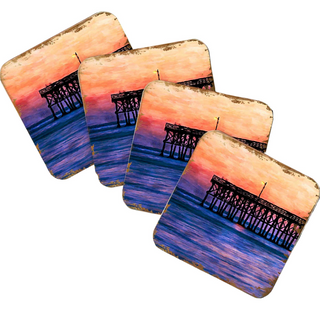 A set of four coasters featuring a sunset over a pier.