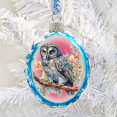 A blue and white ornament featuring a detailed illustration of a gray owl perched on a branch, with a pink and green background.