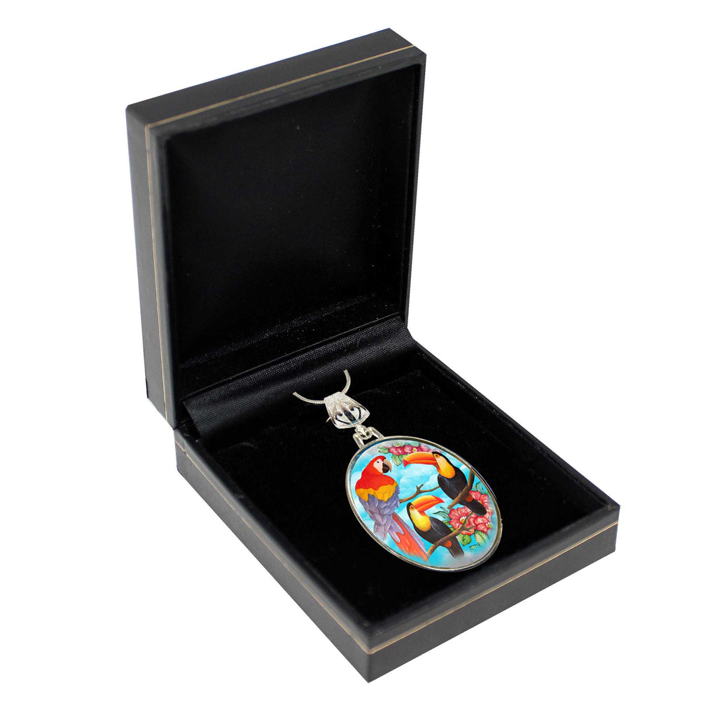 A pendant with a colorful bird design is displayed in a black jewelry box.