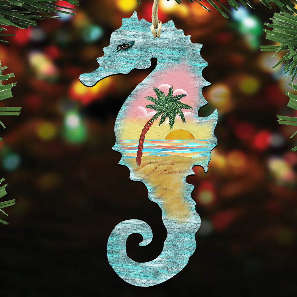 A wooden ornament in the shape of a seahorse, with a tropical beach scene painted on it, is hanging on a Christmas tree.