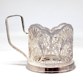 a silver coffee pot with a handle on a white background