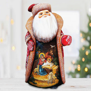 A wooden Santa Claus figurine with a nativity scene painted on it, set against a blurred background with Christmas lights.