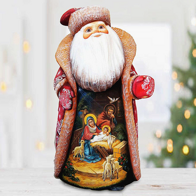A wooden Santa Claus figurine with a nativity scene painted on it, set against a blurred background with Christmas lights.