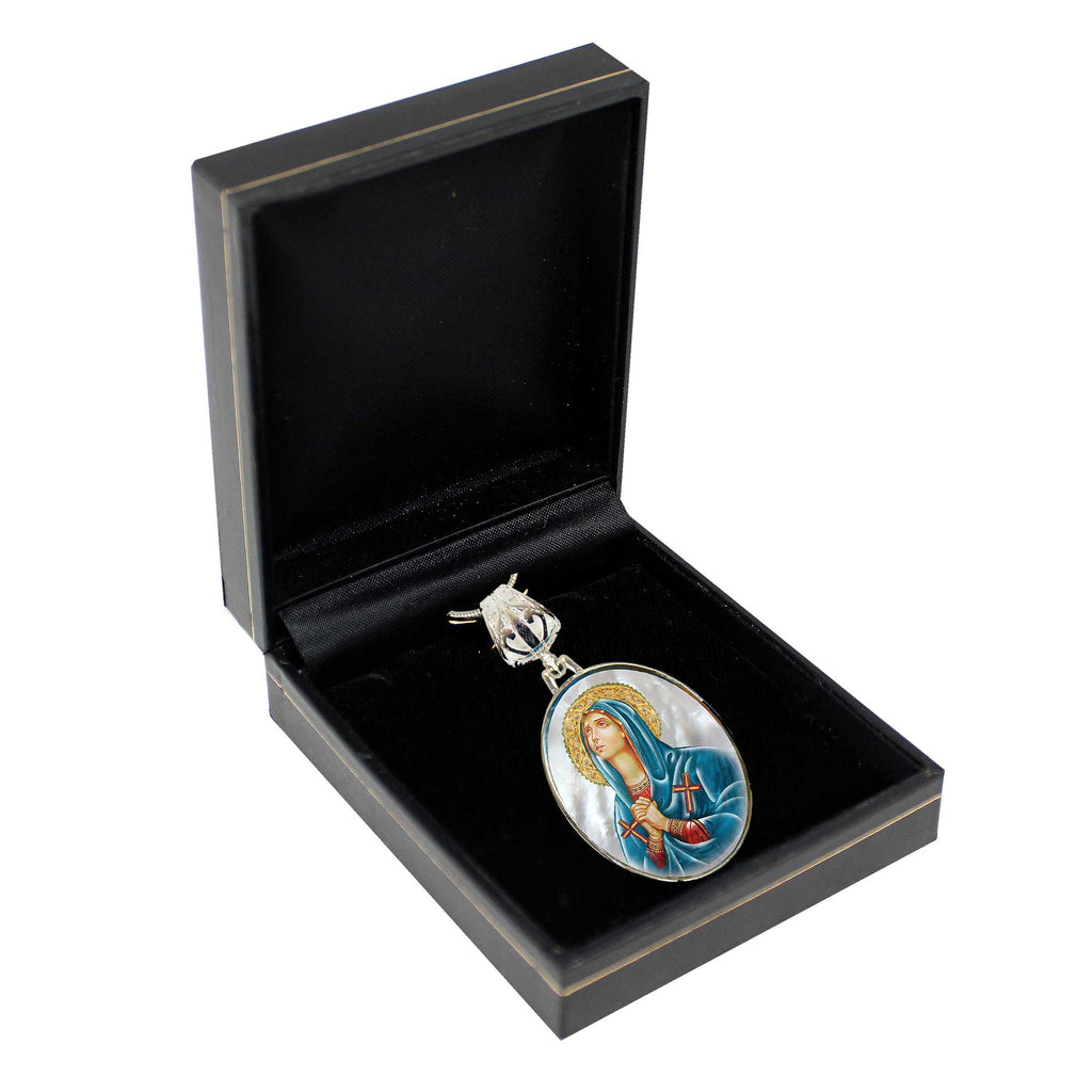 A pendant with a religious icon is displayed in a black jewelry box.