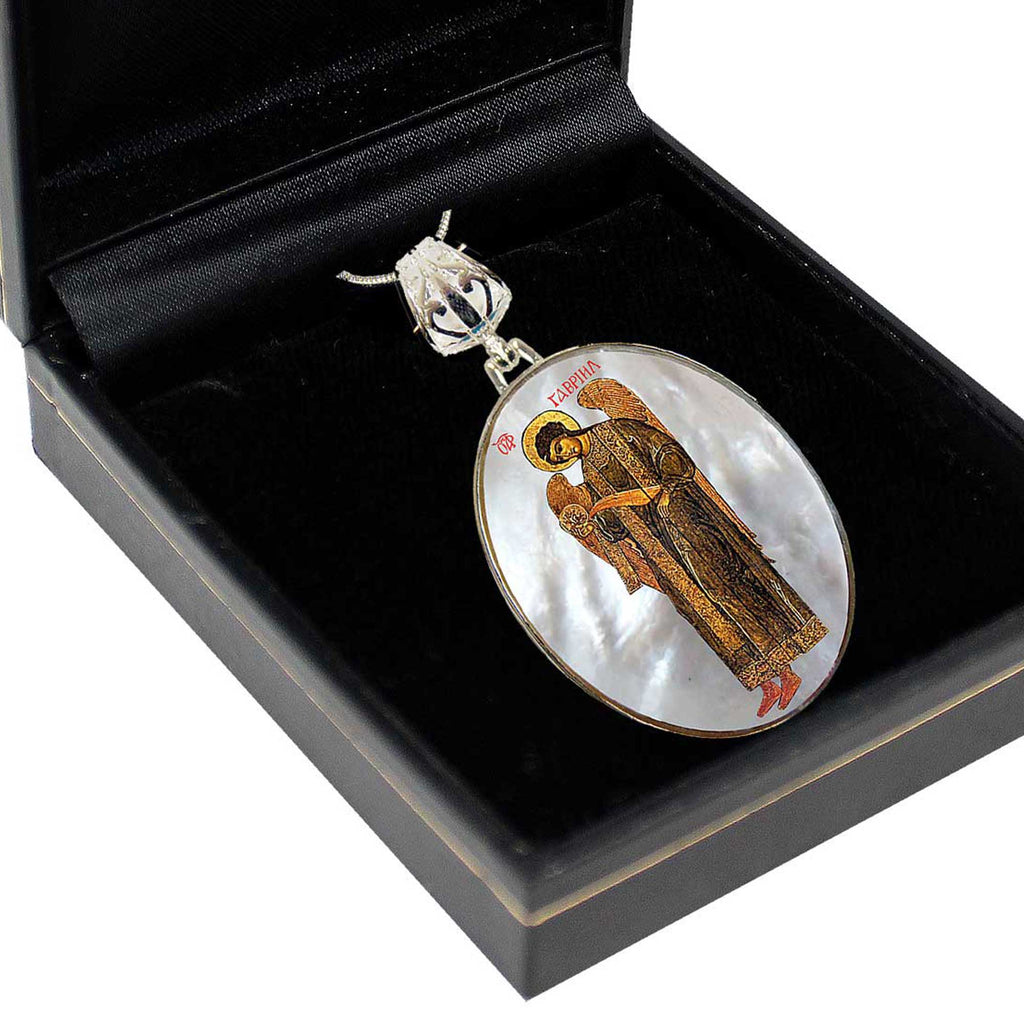 a pendant with an ornate design, placed inside a black display case.