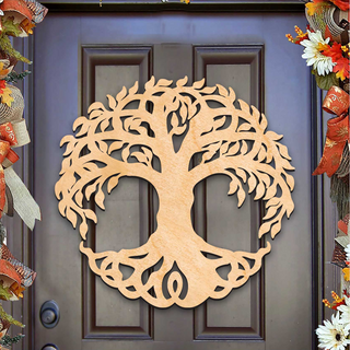 A wooden tree-like decoration is mounted on a dark wooden door, surrounded by colorful fall decorations.