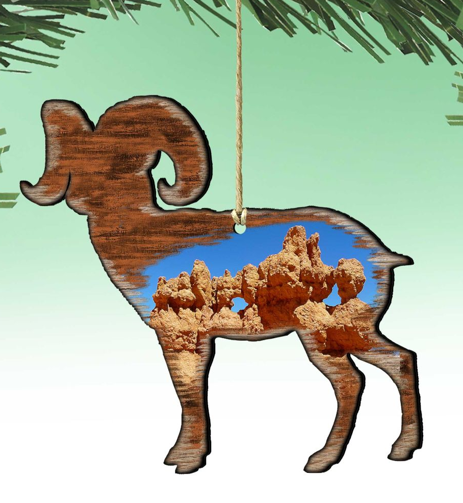 A wooden ornament in the shape of a ram, with a desert landscape visible through the cutout.