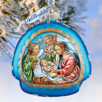 A blue ornament with a painting of the Holy Family, including the Virgin Mary, baby Jesus, and the wise men, hanging on a tree branch.